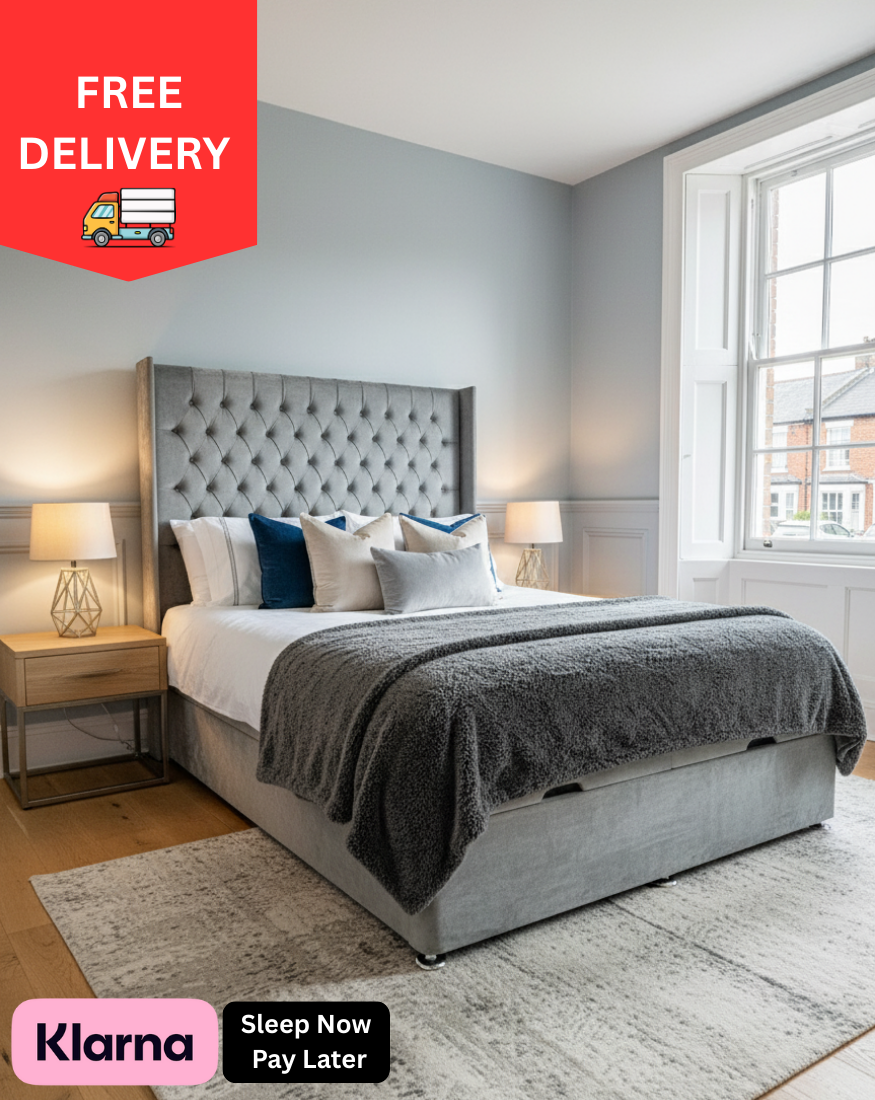 Gray upholstered bed with decorative pillows in a bedroom setting, featuring free delivery and Klarna payment options.