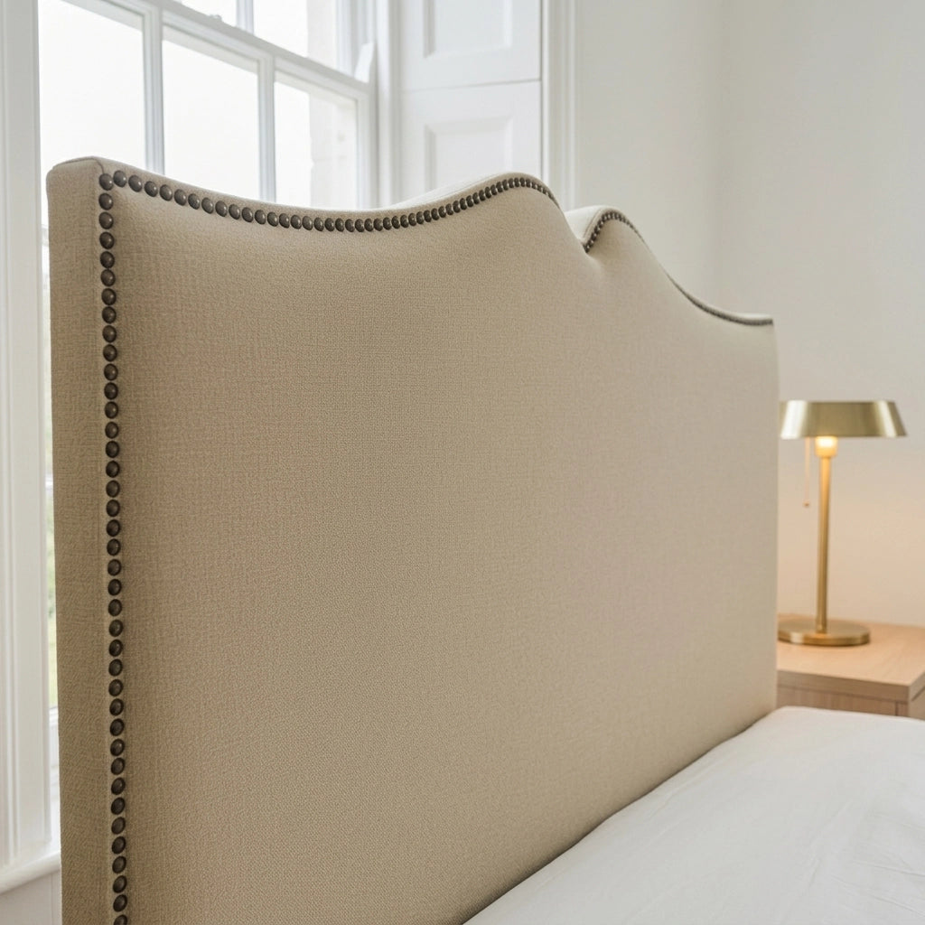 Close-up of camel wool fabric curved headboard with dark decorative stud detailing